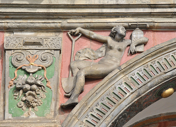 Diese Frauenfigur mit Uhr und Spaten an der Rathausfassade (3. Arkadenbogen) symbolisiert die Arbeit