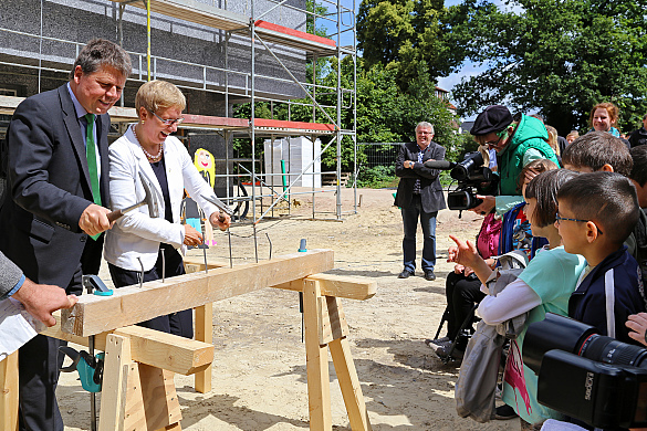 Senatorin Quante-Brandt und Senator Lohse schlagen symbolisch Nägel ein für das neue Quartiersbildungszentrum in Bremen-Gröpelingen