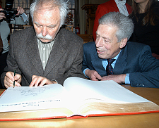 Janosch (links) malt sich zur Freude von Bürgermeister Henning Scherf in das Goldene Buch der Stadt ein. Foto: Senatspressestelle