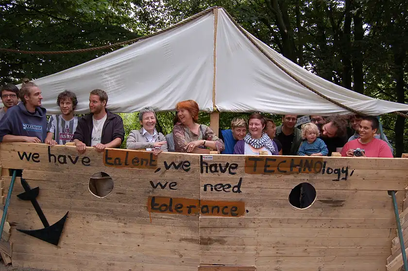 Bürgermeisterin Karoline Linnert mit Mitgliedern des „Zucker-Clubs“ auf dem Holzschiff Ronja – die Inschrift ist Programm für das alternative Netzwerk: „we have talent, we have technology, we need tolerance“  