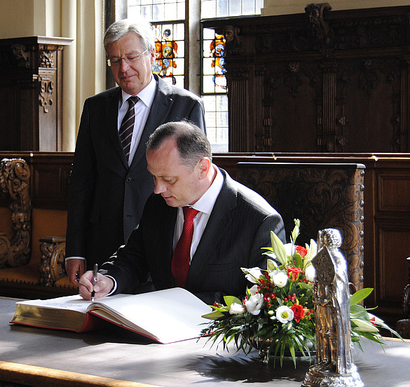 Botschafter Andrei Giro trägt sich bei Bürgermeister Jens Böhrnsen ins Goldene Buch der Stadt ein