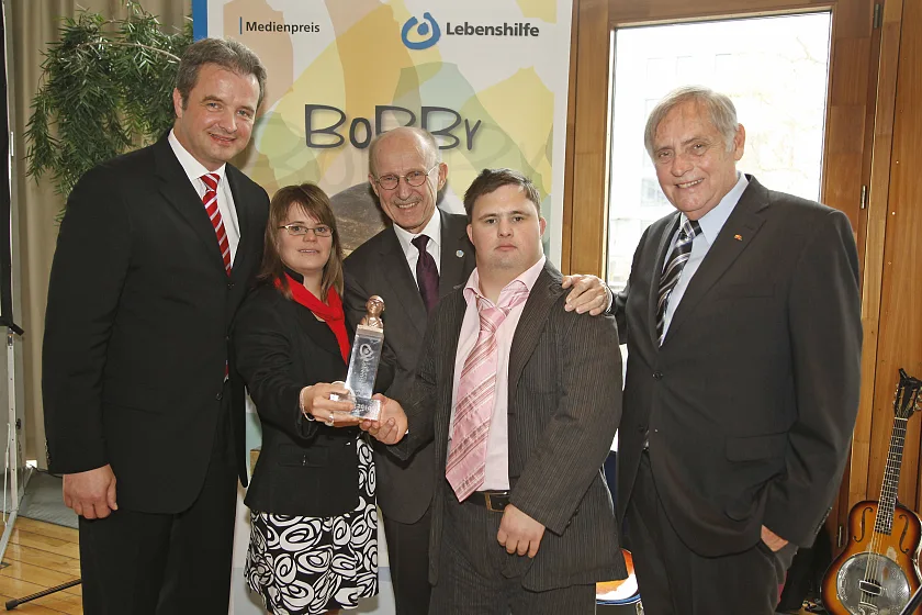 Willi Lemke (Mitte) wurde mit dem BOBBY 2010 der Bundesvereinigung Lebenshilfe ausgezeichnet. Das Bild zeigt ihn zusammen mit der letztjährigen Preisträgerin Juliana Götze, Schauspielerin mit Down-Syndrom, und Peter Mäntele, Goldmedaillen-Gewinner bei den Weltspielen von Special Olympics im Eiskunstlauf. Rechts: Lebenshilfe-Bundesvorsitzender Robert Antretter, links Bundesgeschäftsführer Ulrich Bauch.