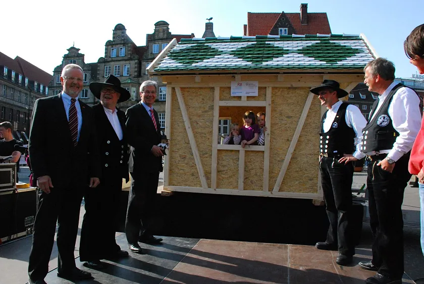 Drei Kinder aus den Kitas Reepschlägerstraße und Rekumer Straße sind schon  in ihr neues Spielhäuschen"eingezogen". Karl-Heinz Schreiber (Präsident Zentralverband des Deutschen Dachdeckerhandwerks), Ullrich Huth (Vorsitzender Holzbau Deutschland), Bürgermeister Jens Böhrnsen, Han Hermann Bellmer, Holzbau Bremen, und der Obermeister der Bremer Dachdecker-Innung Lutz Detring (v.l.) freuen sich mit.