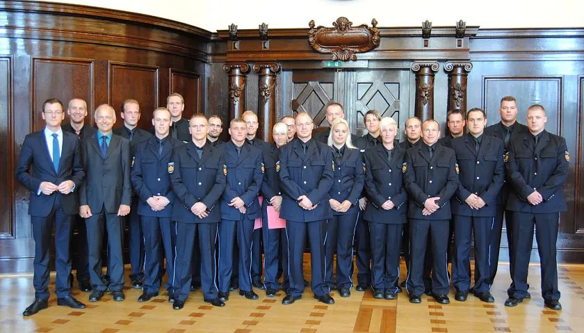 v.l.: Justizsenator Martin Günthner, Hans-Jürgen Erdtmann (stellv. Leiter der JVA) und Leiter der JVA, Dr. Carsten Bauer zusammen mit den diesjährigen Absolventinnen und Absolventen im Justizvollzugsbereich