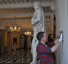 Hausmeister Jens Liermann beim Anbringen der neuen Texttafel zu Bürgermeister Johann Smidt