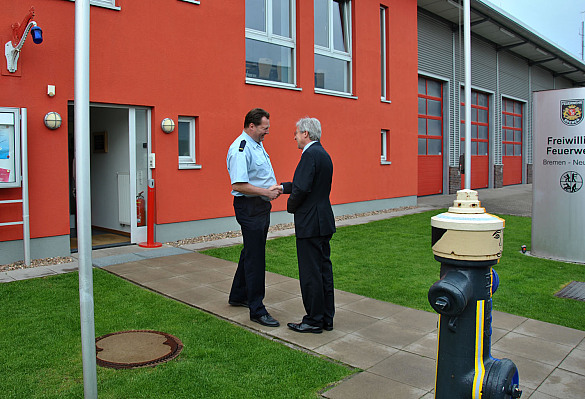 Wehrführer Marcus Schleef begrüßt Bürgermeister Jens Böhrnsen vor dem Feuerwehrgebäude der Freiwilligen Feuerwehr Neustadt