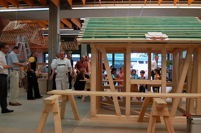 Senatorin Anja Stahmann und die Kinder vom Kinder- und Familienzentrum Mühlheimer Straße besichtigen das fast fertige Spielhaus im Kompetenzzentrum HandWERK  