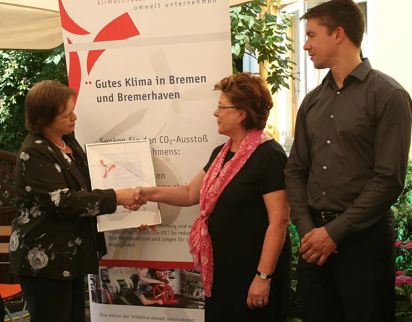Umweltstaatsrätin Gabriele Friderich gratuliert Christel und Nils Plewnia, Geschäftsführung Hotel Westfalia,  zur Auszeichnung als "Klimaschutzbetrieb CO2 - 20" 2012.