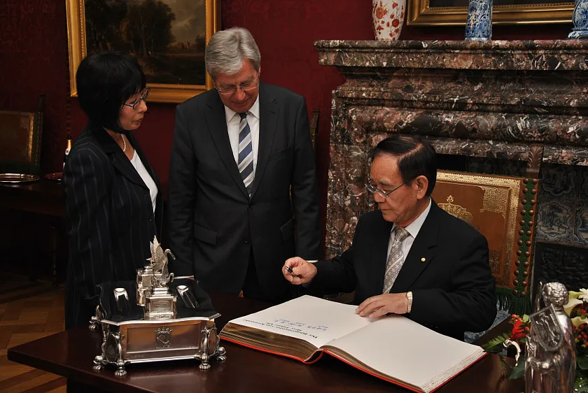 Der  Bürgermeister der Stadt Kawasaki, Takao Abe, trägt sich ins Goldene Buch der Stadt ein