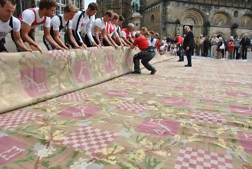 Schwerstarbeit auf dem Grasmarkt: Der Teppich wird aufgerollt