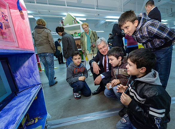 Bürgermeister Böhrnsen lässt sich von teilnehmenden Kindern die Gestaltung einer der Mini-Zon-Mais erläutern 