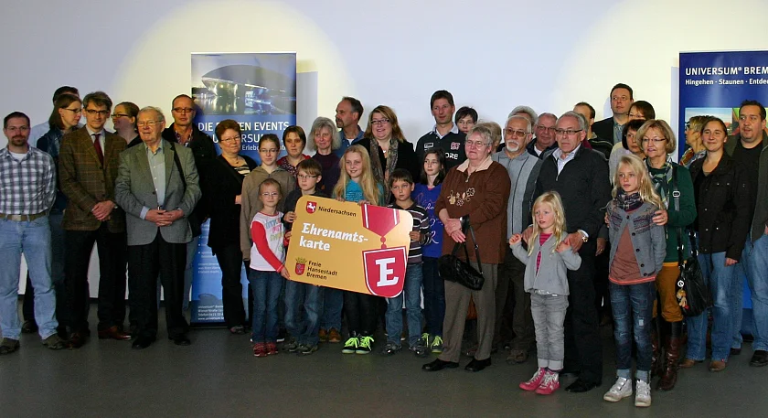Senatorin Anja Stahmann (Bildmitte) und Frank Müller von der Öffentlichen Versicherung Bremen (ÖVB, 4.v.re.) begrüßen die Ehrenamtlichen und ihre Familien im Universum (R)