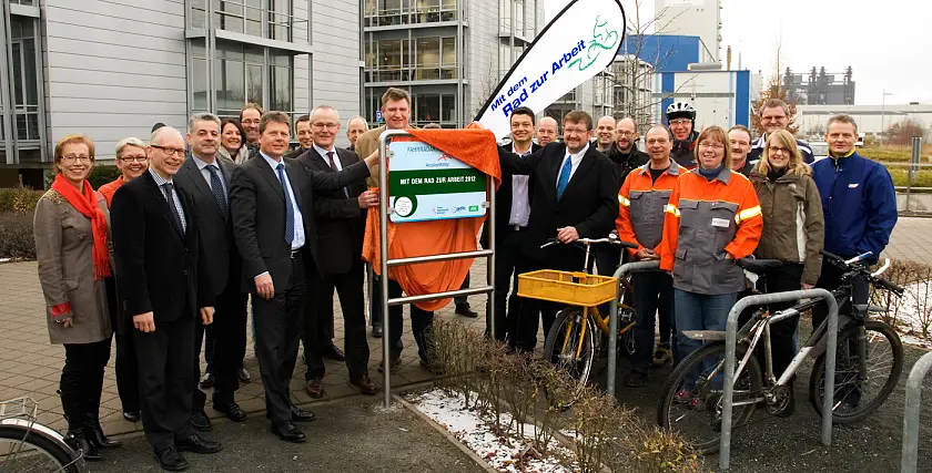 Gruppenfoto mit den Teilnehmer/innen von Arcelor Mital an der Aktion "Mit dem Rad zur Arbeit": Mit der Hand am Schild (v.li.) Senator Dr. Joachim Lohse, Heinzpeter Mühl (Vorstand AOK Bremen/Bremerhaven), Rainer Hamann (ADFC-Vorstandsmitglied), Markus Bendig (stellv. Betriebsratsvorsitzender) und Peter Scherrer (Arbeitsdirektor). Links von Senator Lohse stehen: Dr. Dietmar Ringel (Vorstandvorsitzender), Jörn Pufpaff (Vorstand Primary) und Marion Müller-Achterberg (Unternehmenskommunikation)