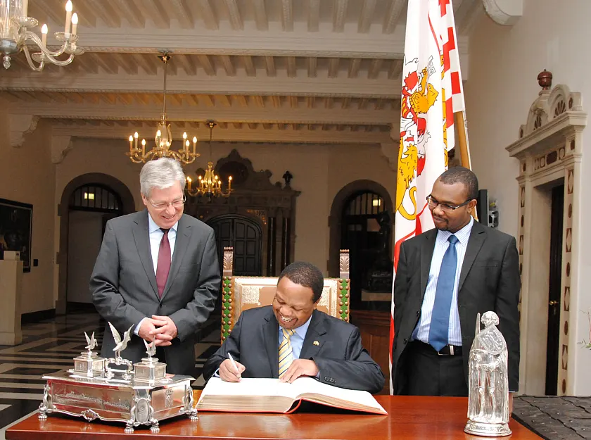 Botschafter Ken Nyauncho Osinde trägt sich in das Goldene Buch der Stadt ein – zur Freude von  Bürgermeister Jens Böhrnsen (links) und  Wirtschaftsattaché Oliver Otieno Konje
