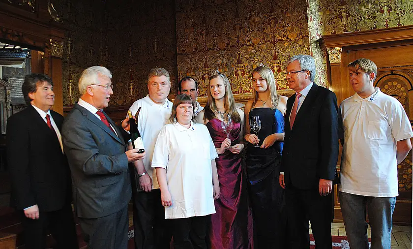 Feierliche Weinübergabe in der Güldenkammer: Ratskellermeister Karl-Josef Krötz, Martinshof-Geschäftsführer Wilfried Hautop, die Martinshof-Beschäftigten Udo Witt, Michaela Kirschke und Bartosz Kafarski, Weinkönigin Lydia I mit Prinzessin Franziska, Bürgermeister Jens Böhrnsen und Andre Sarwatka vom Martinshof (v.l.)