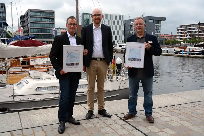 Urkundenüberreichung anlässlich der Neuaufnahme in die „Partnerschaft Umwelt Unternehmen“. V.l.n.r.: Jens Knauer (Inhaber EDEKA Center Roter Sand), Umweltstaatsrat Ronny Meyer, Rüdiger Magowsky (Hotelmanager im-jaich OHG)