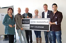 Bürgermeisterin Karoline Linnert schraubte zusammen mit Florian  Rosowski (Schüler der Klasse V12), Schuldirektor Holger Wendel, Sandra Ponke (Schülerin der Klasse V12), Marco Bode (Aufsichtsratsmitglied von Werder Bremen) und Özenc Sencan (Schüler der Klasse V12) das Schild "Schule ohne Rassismus – Schule mit Courage" im Flur der Verwaltungsschule an