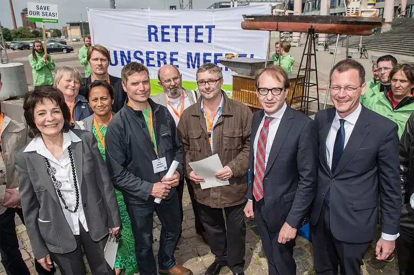 Senator Günthner, EU-Kommisarin Damanaki und Bundesminister Dobrindt zusammen mit Vertreterinnen und Vertretern von Greenpeace, die gegen die Vermüllung der Meere und für einen schonenden Umgang mit Naturressourcen protestieren