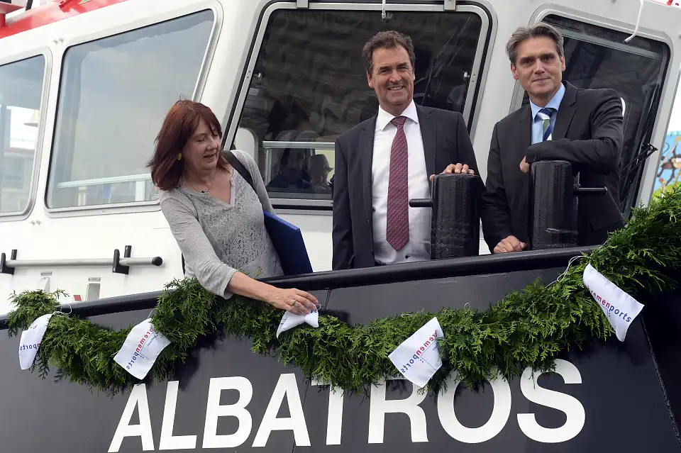 Schiffstaufe in Bremerhaven. Das Foto zeigt die Taufpatin Karoline Linnert mit Frank de Lange von der niederländischen Bauwerft Damen Shipyards (Mitte) und bremenports-Geschäftsführer Robert Howe. Die Flasche zersprang auf Anhieb – so soll es sein