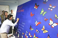 VHS-Dozentin  Rong Fang Cao bringt chinesische Schriftzeichen auf dem Bild von Sonja Schadwinkel (dahinter stehend) an. 