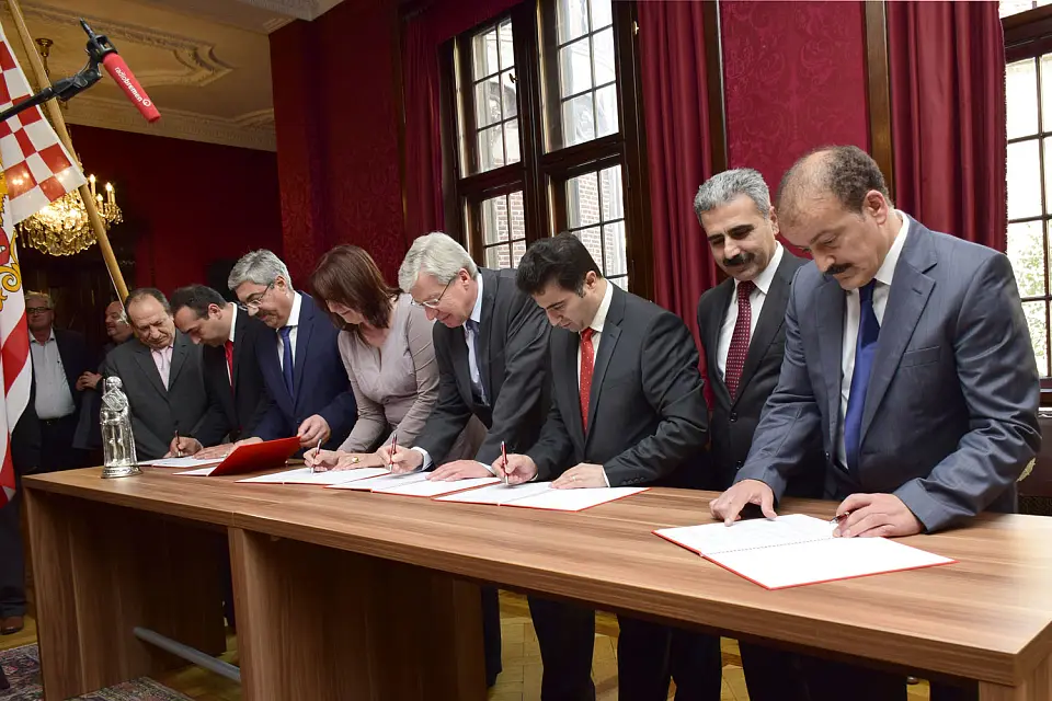 Feierliche Unterzeichnung des Vertrags im Kaminsaal des Rathauses: (v.r.n.l.)  Manuel Diskaya, Cafer Kaplan (Vorsitzender des Geistlichen Rats),  Hüseyin Mat, Bürgermeister Böhrnsen, Bürgermeisterin Linnert, Oberbürgermeister Grantz, Serdar Kara und Sadýk Köylü.
