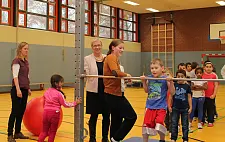 Turnen am Reck. Senatorin Quante-Brandt, Übungsleiterin Elke Eichstaedt