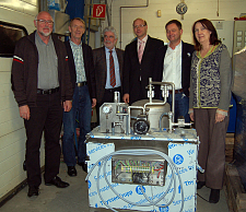 Die Bürgermeisterin mit Vertretern der Interessensgemeinschaft Huchtinger Unternehmer vor einer Dino-Dampfmaschine.
