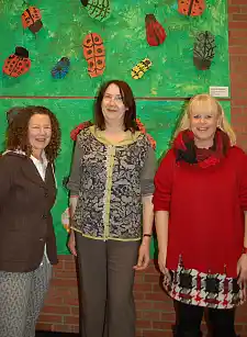 Frauke Brandt, Karoline Linnert und Birgit Bode (von links) vor einem bunten Wandschmuck, den Schülerinnen und Schüler der Grundschule Delfter Straße selbst hergestellt haben.