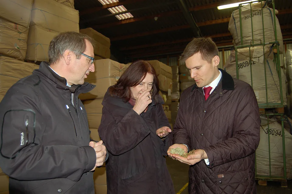 Patrick Winten, Karoline Linnert und Andreas Berghöfer (v.l.n.r.) in einem Lagerraum der Firma roha arzneimittel. Die Bürgermeisterin schnuppert an einer Sennaprobe aus Indien