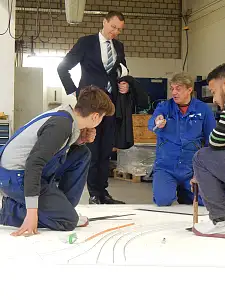 Auszubildende der BVT Bremen GmbH zeigen Senator Günthner, wie Stahl verformt wird