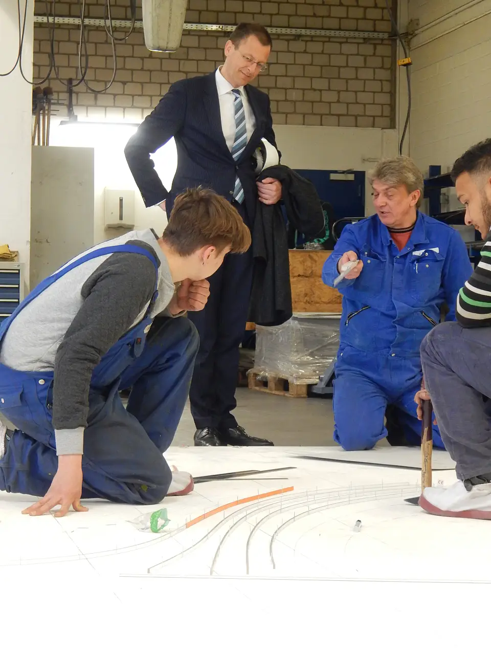 Auszubildende der BVT Bremen GmbH zeigen Senator Günthner, wie Stahl verformt wird