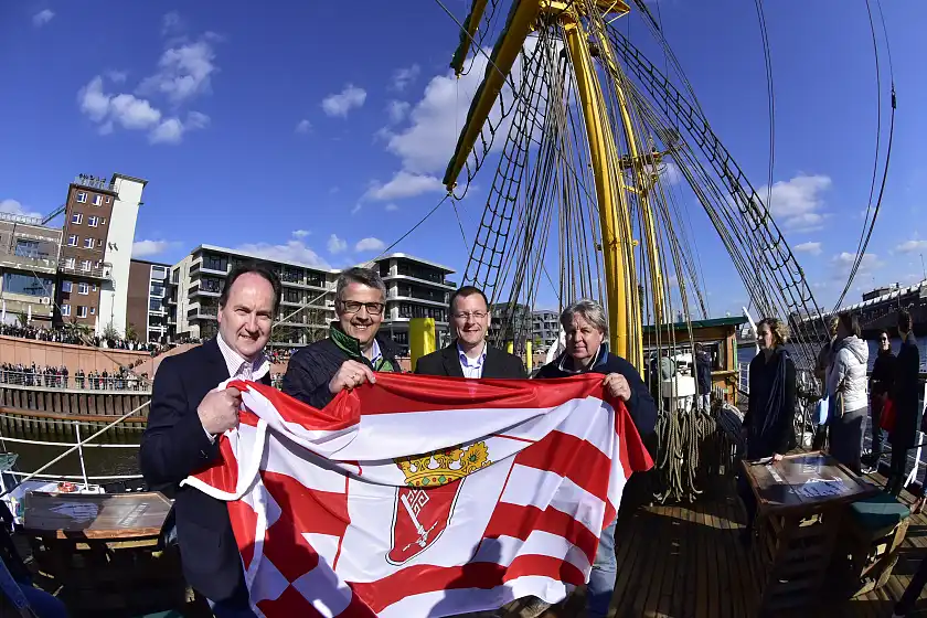 Herzlich willkommen, Alexander von Humboldt! Peter Siemering (Geschäftsführer der BTZ Bremer Touristik-Zentrale), Andreas Heyer (Vorsitzender der WFB Wirtschaftsförderung Bremen GmbH) und  Wirtschaftssenator Martin Günthner (Der Senator für Wirtschaft, Arbeit und Häfen der Freien Hansestadt Bremen) überreichten Schiffseigner Heiko Rataj die Bremer Flagge. (Personen v.l.n.r.)