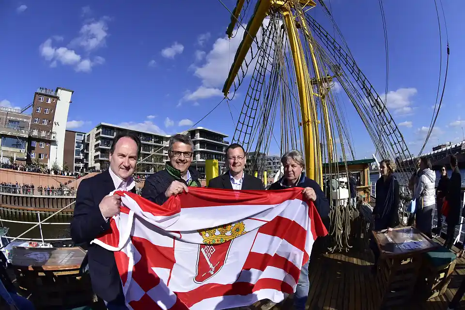 Herzlich willkommen, Alexander von Humboldt! Peter Siemering (Geschäftsführer der BTZ Bremer Touristik-Zentrale), Andreas Heyer (Vorsitzender der WFB Wirtschaftsförderung Bremen GmbH) und  Wirtschaftssenator Martin Günthner (Der Senator für Wirtschaft, Arbeit und Häfen der Freien Hansestadt Bremen) überreichten Schiffseigner Heiko Rataj die Bremer Flagge. (Personen v.l.n.r.)