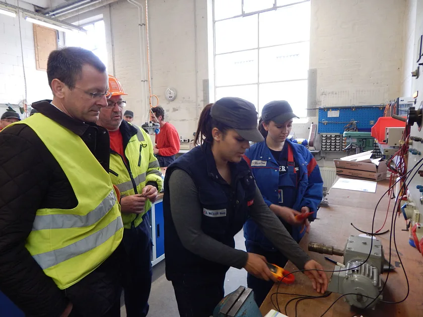 Beim Besuch der J. Müller Weser GmbH & Co. KG lernt Senator Günthner zwei junge Frauen kennen, die zu Elektronikerinnen für Betriebstechnik ausgebildet werden
