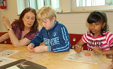 Karoline Linnert formt zusammen mit Schülern der Gazellenklasse den Tatzenabdruck eines Geparden nach