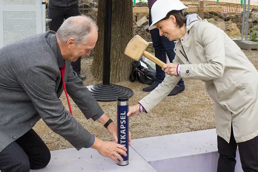 Senatorin Claudia Bogedan und KSA-Schulleiter Andreas Heinrichs versiegeln zusammen die Zeitkapsel zur Grundsteinlegung des Erweiterungsbaus an der KSA