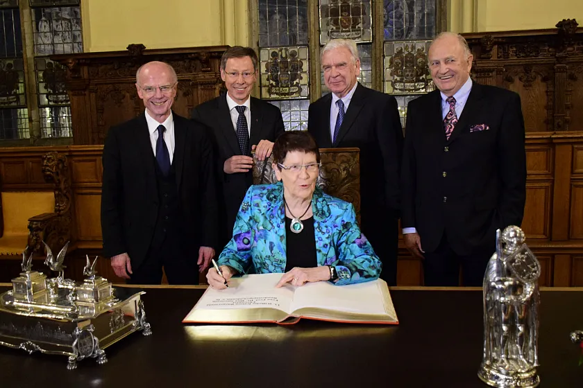 Rita Süssmuth, Ehrengast des Bürgermahls,  trägt sich im Senatsgestühl in der Oberen Rathaushalle in das Goldene Buch ein (v.l.): Bürgerschaftspräsident Christian Weber (Vorstand der WKB), Bürgermeister Carsten Sieling (Kuratoriumsvorsitzender), Ulrich Mosel (stv. Kuratoriumsvorsitzender) und Jürgen L. Born (Kuratoriumsmitglied)