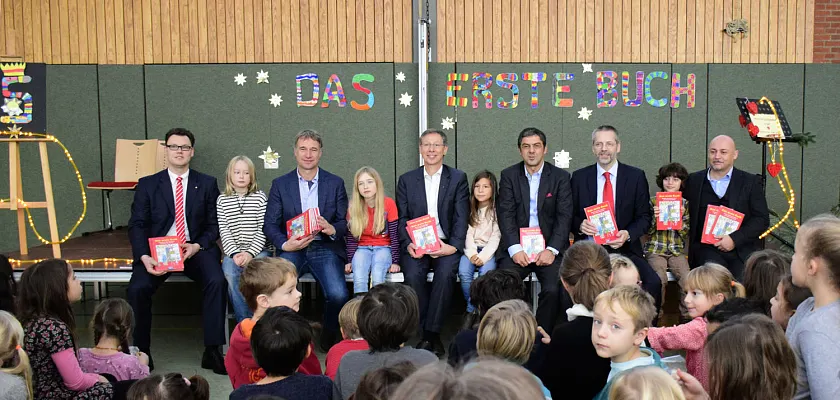 Buchübergabe in der Bürgermeister-Smidt-Schule: E. Servet Mutlu, Hermann Schünemann, Bülent Uzuner, Bürgermeister Carsten Sieling, Marco Bode und Mario Schnibbe freuen sich mit den Kindern über eine tolles Buch (v.r.)