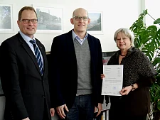 Baustaatsrätin Gabriele Friderich überreicht im Beisein von Amtsleiter Ulrich Gellhaus (li.) dem „Öffentlich bestellten Vermessungsingenieur“ Sebastian Horst die Urkunde