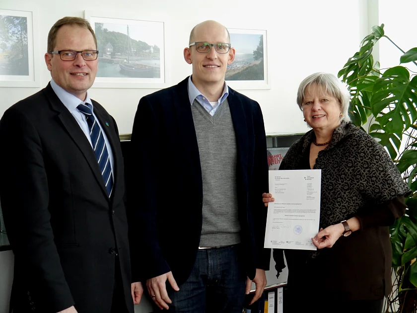 Baustaatsrätin Gabriele Friderich überreicht im Beisein von Amtsleiter Ulrich Gellhaus (li.) dem „Öffentlich bestellten Vermessungsingenieur“ Sebastian Horst die Urkunde
