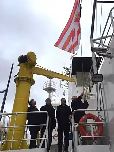 Zum Farewell hissen Kapitän Klaus Vogel, Bürgermeister Carsten Sieling, Bremerhavens OB Melf Grantz und Hans-Joachim Schnitger von der Bremischen Hafenvertretung die Bremer Speckflagge