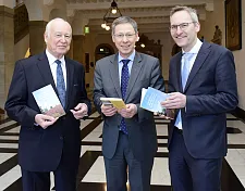 Autor Harald Witt (li.) und Verleger Florian Isensee (re.) überreichen Bürgermeister Carsten Sieling das neue Wanderbuch