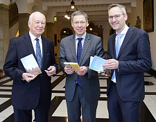 Autor Harald Witt (li.) und Verleger Florian Isensee (re.) überreichen Bürgermeister Carsten Sieling das neue Wanderbuch