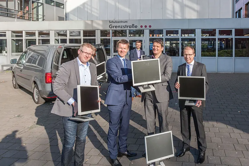 Haben die Bildung auf dem Schirm: hkk-Vorstand Michael Lempe (2.v.l) und der Geschäftsbereichsleiter IT/Digitalisierung Sascha Rosewig  (l.) übergeben die ersten 50 Monitore an Bildungsstaatsrat Frank Pietrzok (2.v.r.) und Schulleiter Peter Hons (r.)