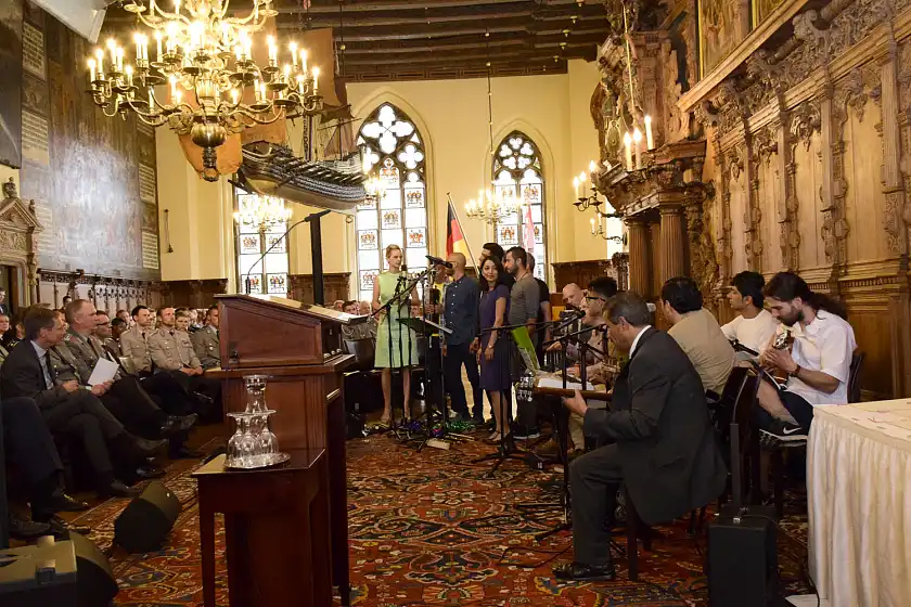 Das aus Flüchtlingen bestehende Ensemble des maritimen Musik- und Theaterprojekts um Frauke Wilhelm beim Liedvortrag