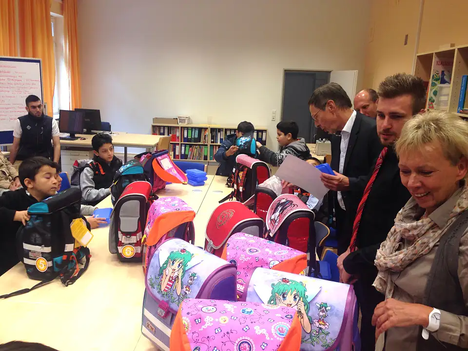 Der Bürgermeister (4. v.r.)  packt den Schulranzen: Auch Stundenplan und Brotdose gehören mit hinein.