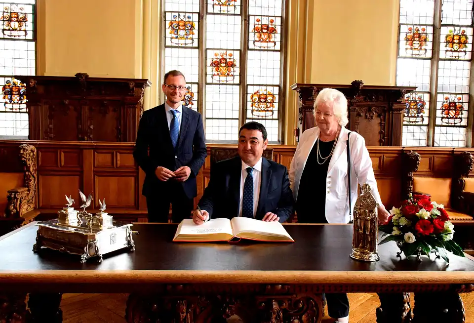 Botschafter Bolat Nussupov beim Eintrag in das Goldene Buch mit Senator Günthner (li.) und Honorarkonsulin Christa Fuchs