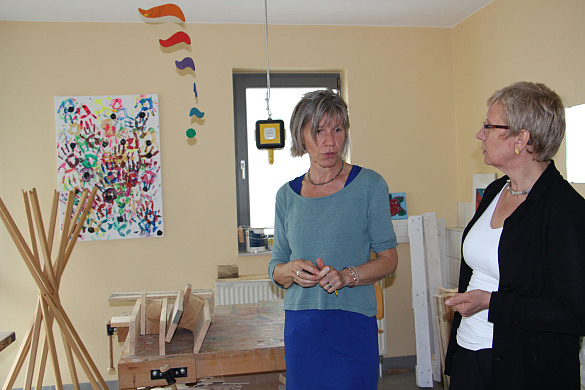Ellen Hartmann, Pflegeleiterin, zeigt Senatorin Eva Quante-Brandt einen der Werkräume für ergotherapeutische Angebote, wie zum Beispiel Holzarbeiten.