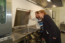 Karoline Linnert und Susanne Kirchmann (rechts) begutachten die Küchenausstattung der neuen Mensa