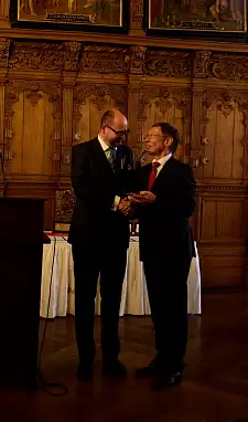 Pawel Adamowicz  überreicht eine Skulptur der Danziger Werfktkräne 